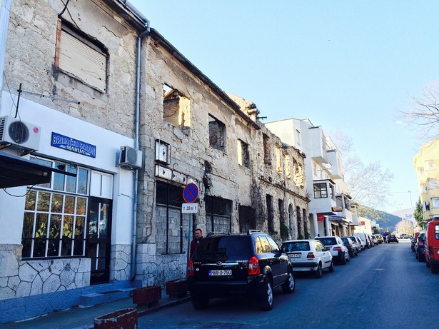 Cars parking near ruined houses