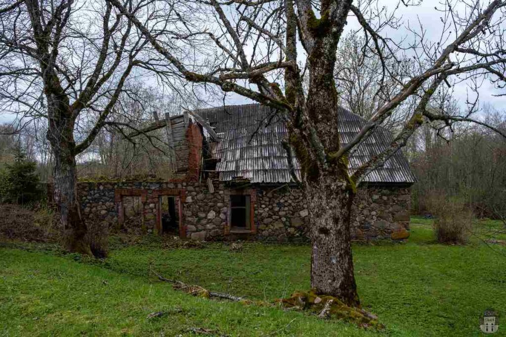 Area surrounding the Tolkas pareizticīgo baznīcas drupas with several ruined houses

